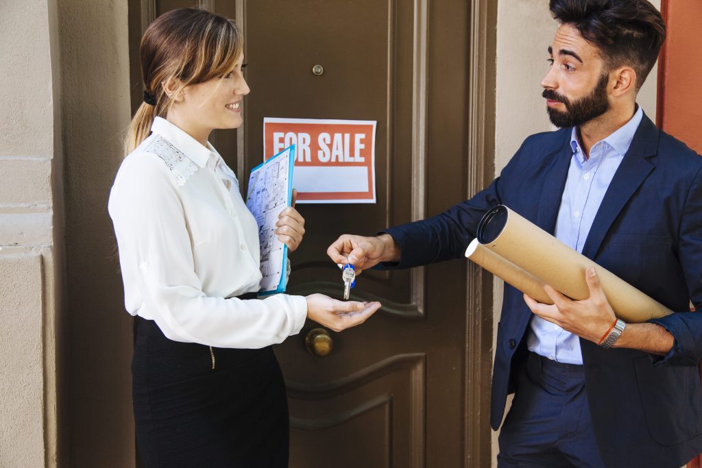 real estate agent giving key business woman min